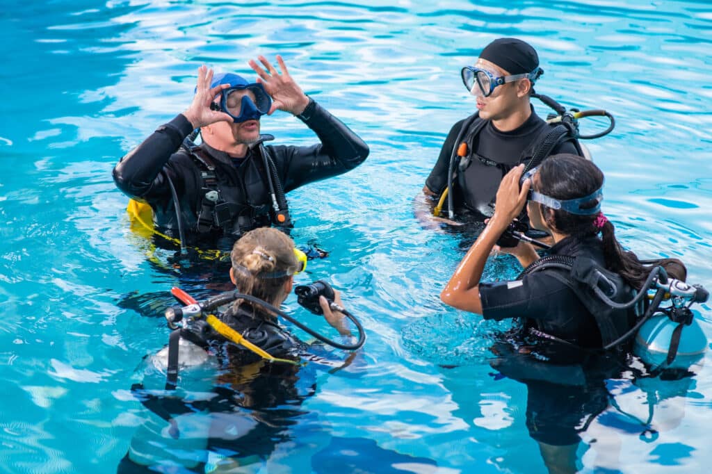 grupo de personas cumpliendo requisitos para hacer el bautismo de buceo